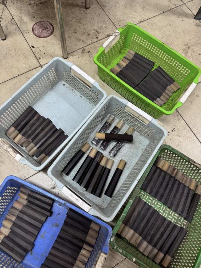 Overhead view of wa handles in production — sorted by wood type in workshop baskets