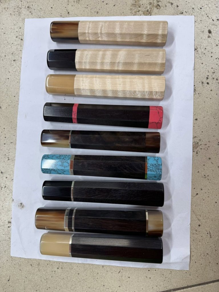 Several complete handles with varied wooden bodies and front ferrules, arranged separately in parallel rows on white paper.