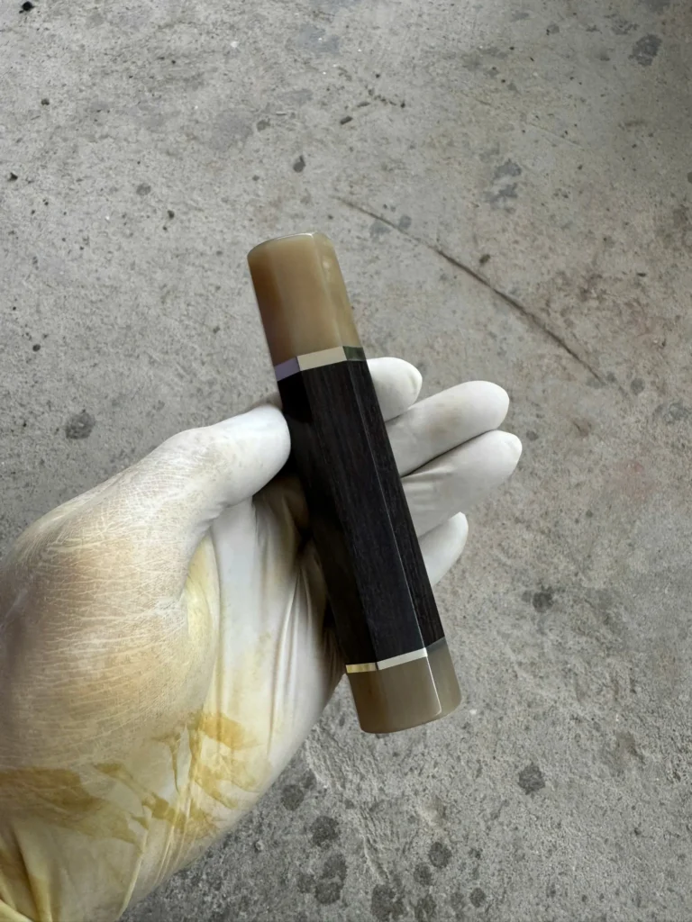 African blackwood handle with a light horn front ferrule and rear end cap, separated from the black body by thin silvery bands.