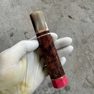 Reddish figured Amboyna burl handle with a pale marbled horn front ferrule, metallic spacers, and pink coral rear end cap.