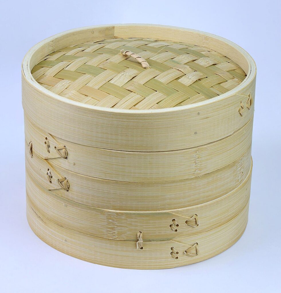 Two bamboo steaming baskets stacked beneath a woven lid