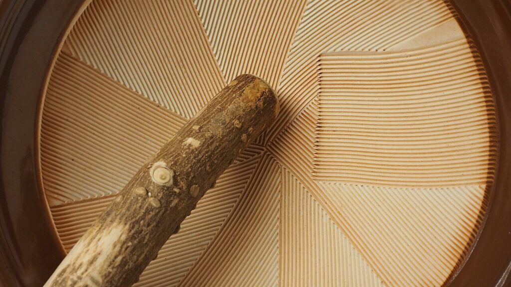 Close view of a suribachi’s ridged interior and wooden surikogi