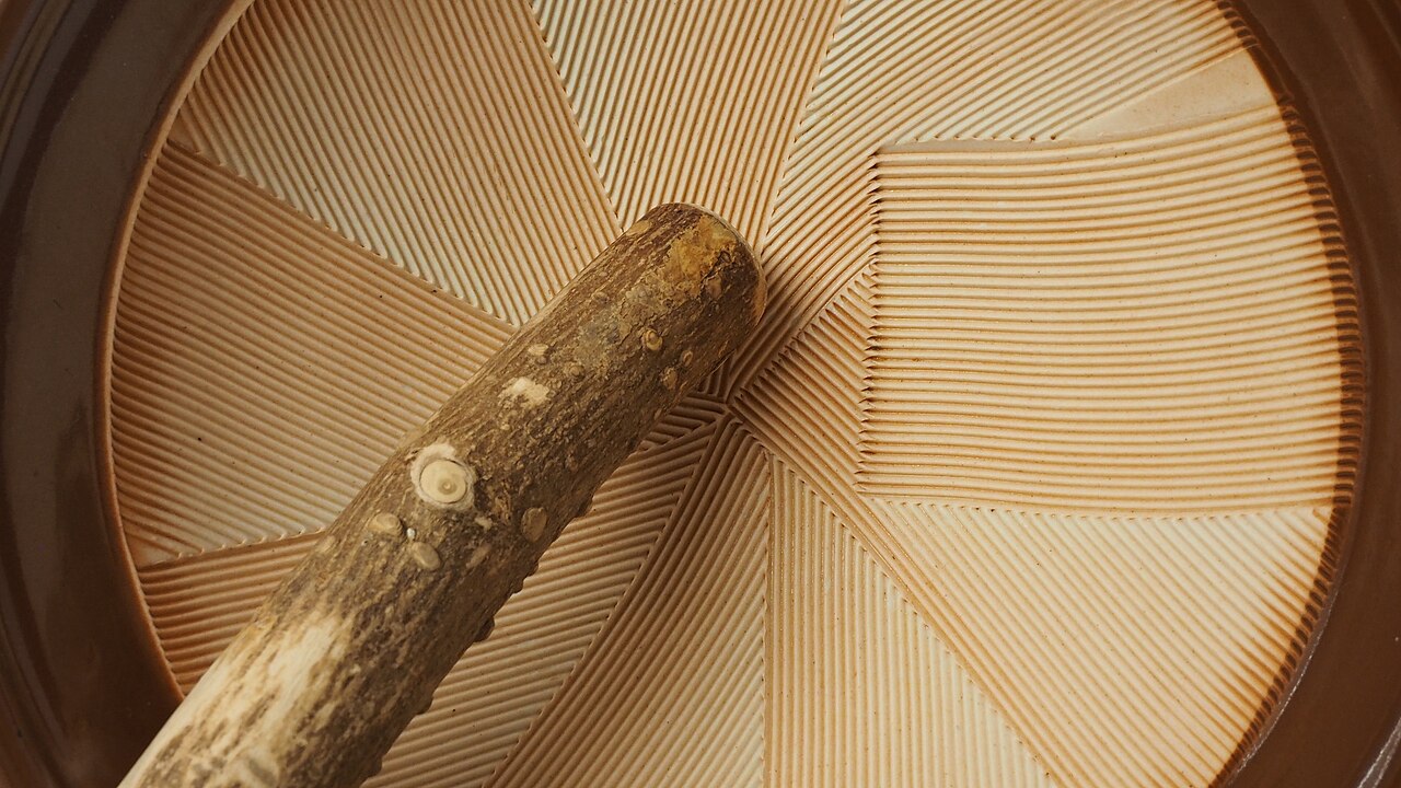 Close view of a suribachi’s ridged interior and wooden surikogi