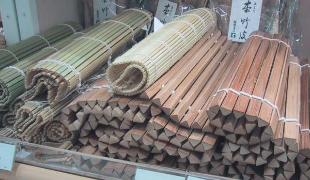 Several rolled bamboo mats with different slat profiles on display