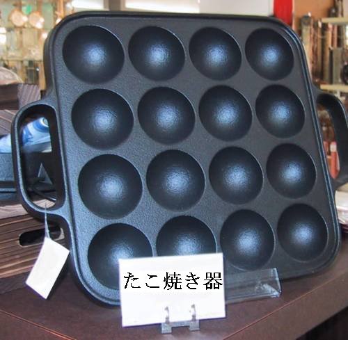 A rectangular takoyaki pan with sixteen rounded wells and two side handles.