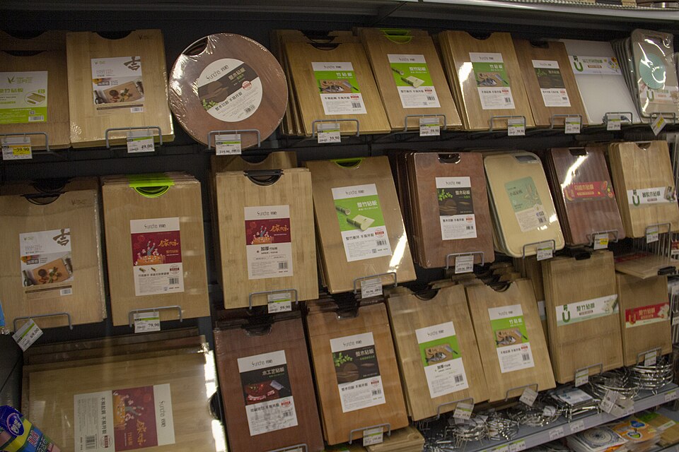 Wooden and plastic cutting boards displayed upright on shop shelves.