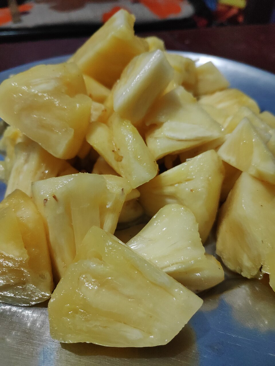 Fresh pineapple cut into irregular chunks and arranged on a plate.
