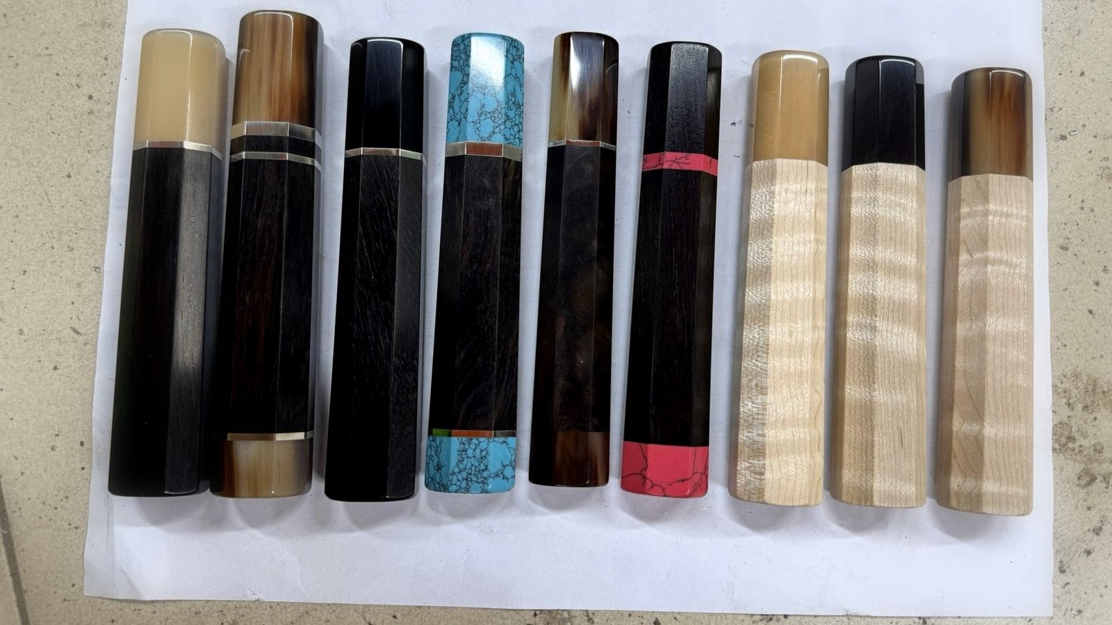 Gyuto and santoku knives with wa handles aligned on a linen work surface