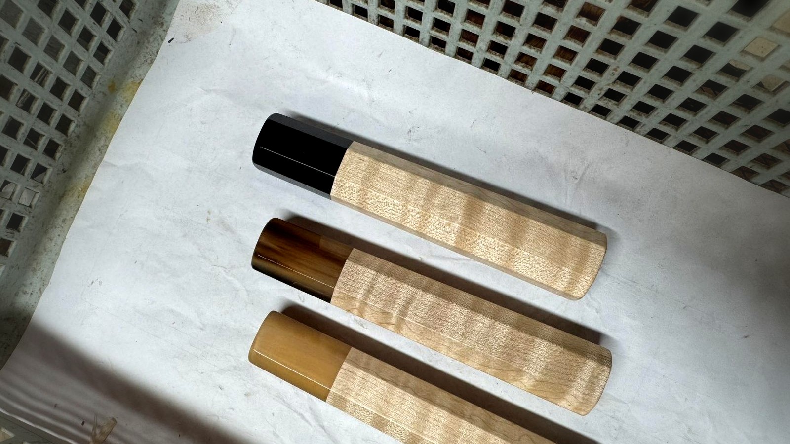 Black buffalo horn ferrules paired with dark and warm wood handles