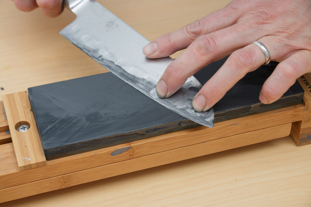 A knife being sharpened on a whetstone