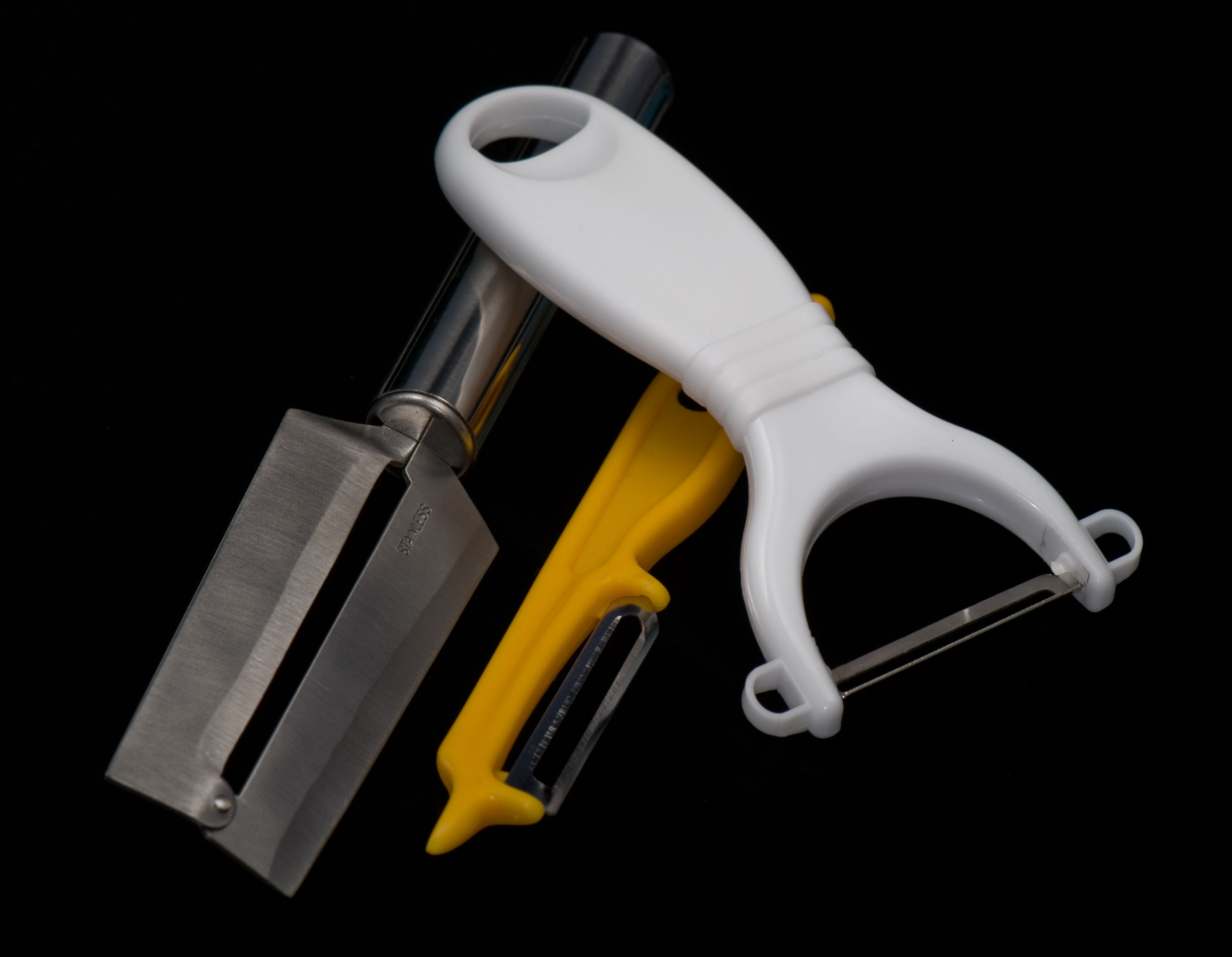 Three different handheld vegetable peeler shapes arranged side by side
